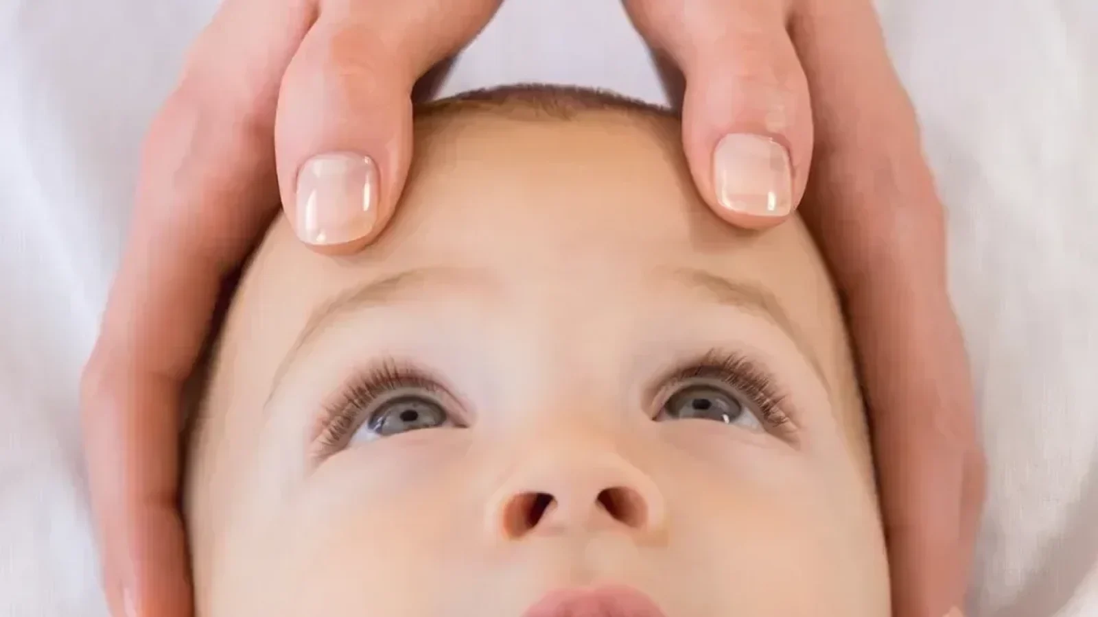 Bebê deitado de barriga para baixo em um tapete claro, apoiado nos braços durante o tempo de barriga para baixo